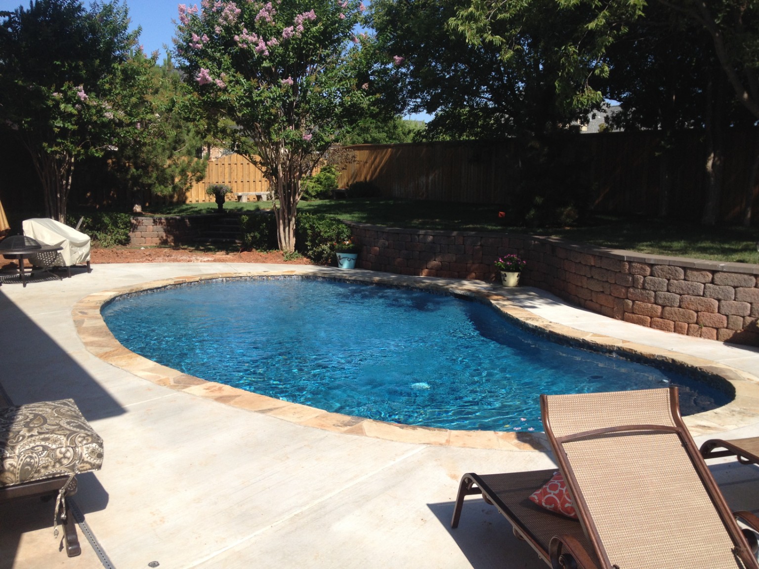Completed freeform backyard pool with natural stone coping